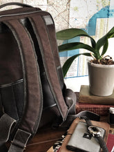 Load image into Gallery viewer, Franklin-Christoph Fortis Backpack with books, map, orchid, notebook, pen, and watch on a wooden table.