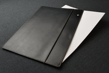 Load image into Gallery viewer, The Franklin-Christoph Document Folder - Black Leather, featuring a snap enclosure, partially covers white sheets of paper on a dark textured surface.