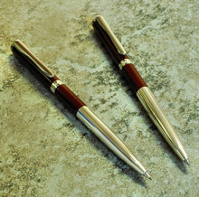 Load image into Gallery viewer, Two Franklin-Christoph Model 07 Dara maroon ballpoints with silver accents rest elegantly on gray stone.