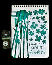 Load image into Gallery viewer, Franklin-Christoph Bottled Ink is next to a notepad with a green floral flag design and handwritten notes.
