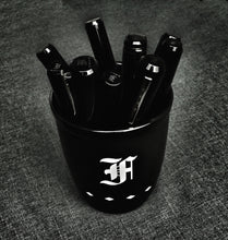 Load image into Gallery viewer, Franklin-Christoph Coffee Mug 1, matte black with a white F, holds black markers on a textured dark gray surface.