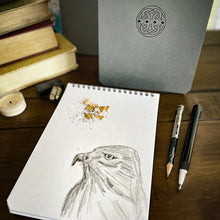 Load image into Gallery viewer, A Franklin-Christoph Greypads spiral pad with an eagle sketch and pencils sits on a wooden table.