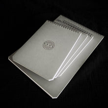 Load image into Gallery viewer, Greypads by Franklin-Christoph: grey archival spiral notebooks with Celtic knot covers, resting on black fabric.
