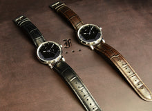 Load image into Gallery viewer, Two Franklin-Christoph IWO Timepieces with leather straps, black and brown, on brown surface with fancy F logo.