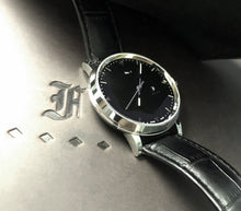 Load image into Gallery viewer, A Franklin-Christoph IWO Timepiece sits on a surface embossed with an ornate letter F.