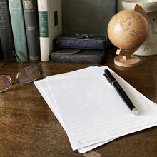 Load image into Gallery viewer, Franklin-Christoph Loose Leaf Sugar Paper with a pen, on desk with glasses, books, and a wooden globe in the background.