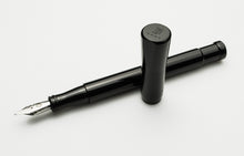 Load image into Gallery viewer, A Franklin-Christoph Model 50 Grandis Fountain Pen in solid black with a silver nib rests on a white background.