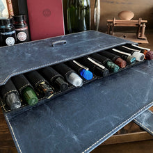 Load image into Gallery viewer, Franklin-Christoph’s New Penvelope 12 NWF holds twelve pens, features vegan material, and is shown on a wooden desk.