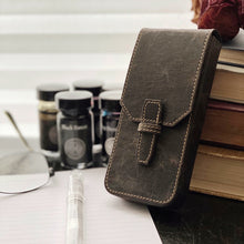 Load image into Gallery viewer, The Franklin-Christoph New Penvelope 3 NWF sits by books, glasses, ink bottles, and paper on the desk.