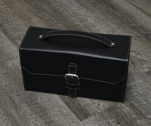 Load image into Gallery viewer, Black leather briefcase with handle and buckle, next to Franklin-Christoph The Christoph 48 Pen Case on wood floor.