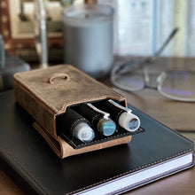 Load image into Gallery viewer, Three pens in a Franklin-Christoph pen case with Pen Case Inserts rest on a closed notebook, glasses, and candle.