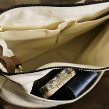 Load image into Gallery viewer, Open Franklin-Christoph Fortis Sling Bag - Creme’ and Brown, revealing a patterned and a dark blue item inside.
