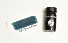 Load image into Gallery viewer, A glass Franklin-Christoph Bottled Ink and a swatch with handwritten text on a white card.