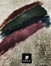 Load image into Gallery viewer, Three smudged stripes—red, green, and purple—on waxed canvas above a small black patch with a white H.