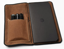 Load image into Gallery viewer, Franklin-Christoph Vagabond Notebook Covers - Canvas, with pens in pocket, shown from above on white background.