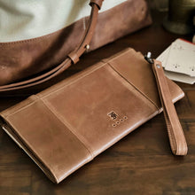 Load image into Gallery viewer, A Fortis Clutch Envelope - Creme’ and Brown by Franklin-Christoph rests on water repellent canvas near playing cards.