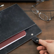 Load image into Gallery viewer, Hand opening a Franklin-Christoph Document Folder - NWF Colors; glasses and pen on wood fiber desk.