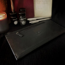 Load image into Gallery viewer, Franklin-Christoph EDC Travel Wallet in black leather, shown with pens, ink, books, and a candle on a dark surface.