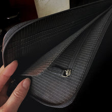 Load image into Gallery viewer, A hand opens an empty Franklin-Christoph EDC Travel Wallet with multiple compartments and a dark fabric lining.