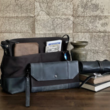 Load image into Gallery viewer, A water-repellent black and brown canvas bag with books, map, glasses, and a Franklin-Christoph Fortis Clutch Envelope.