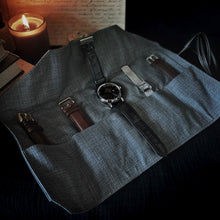 Load image into Gallery viewer, Franklin-Christoph’s 5 Watch Roll in Black Leather &amp; Suit Grey sits by a candle, books, and handwritten notes.