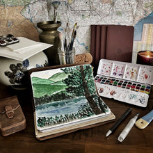 Load image into Gallery viewer, Franklin-Christoph’s Water Color Paper - VN Refill with brushes, notebooks, and a candle in a landscape painting scene.