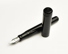 Load image into Gallery viewer, The Franklin-Christoph Model 20p pocket Fountain Pen - Classic Black with silver nib rests uncapped on white.